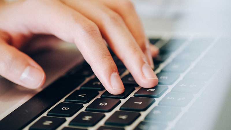 Close-up of hands on a laptop keyboard