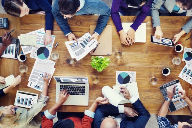 overhead view of people discussing data at a desk