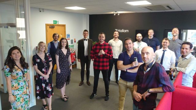 Group of Hallam staff smiling in the office