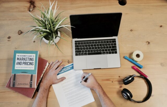 laptop, paper and marketing book