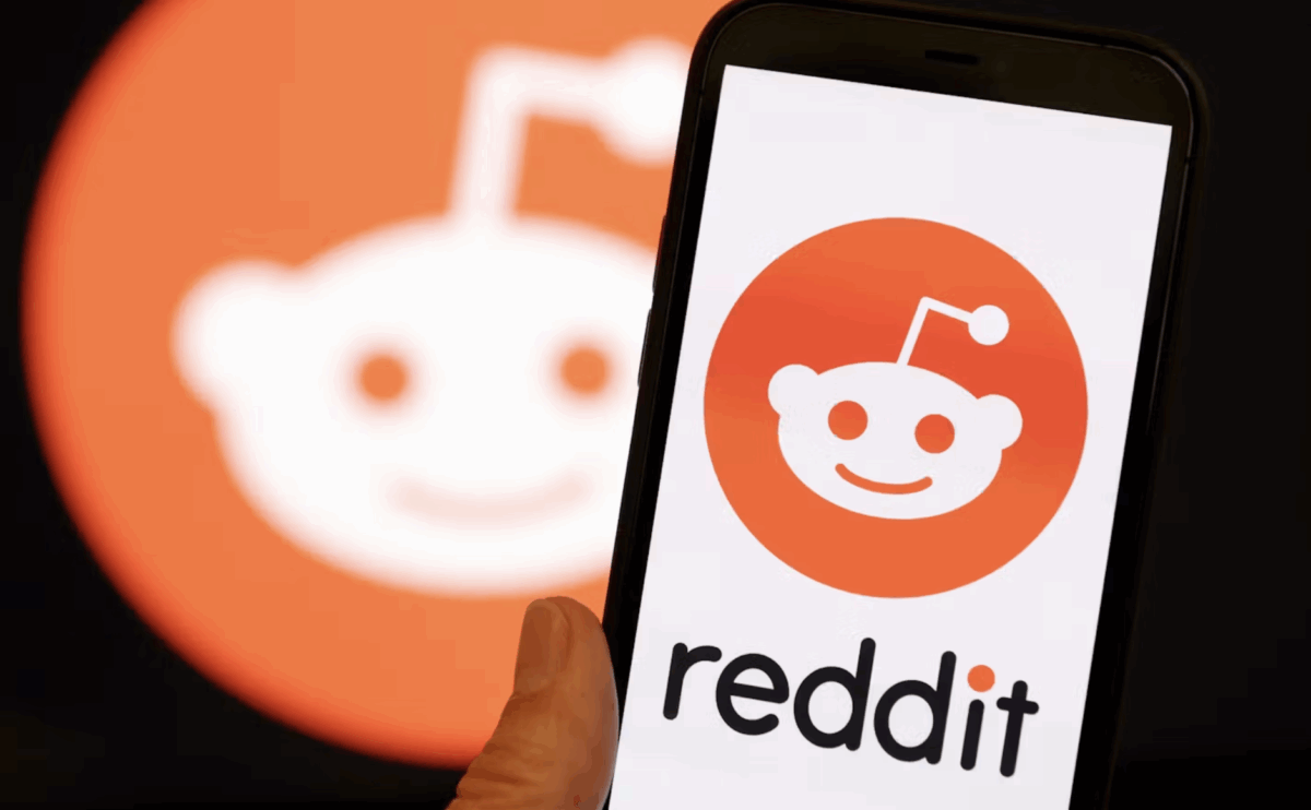 A mobile phone displaying the Reddit logo